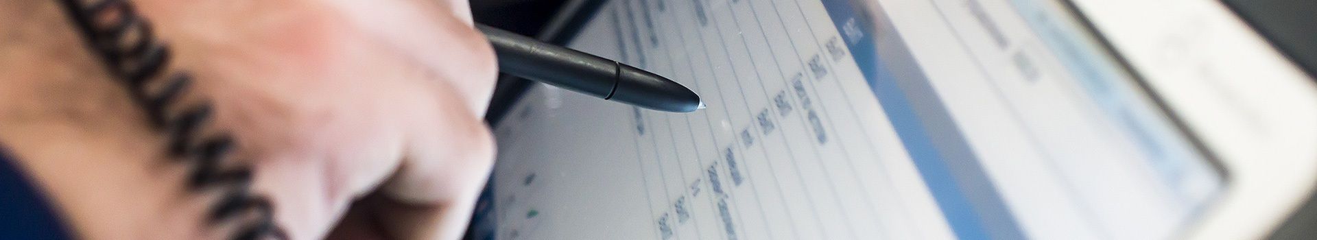 Person tippt mit einem Stift auf einen Touchscreen